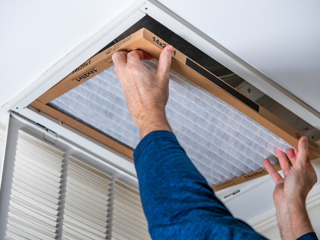 HVAC technician replacing a home air filter in San Clemente