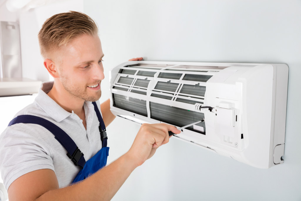 HVAC technician maintaining a ductless air conditioner in San Clemente