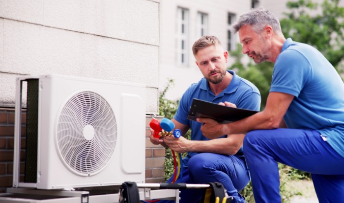 HVAC technicians installing an outdoor air conditioning unit in San Clemente